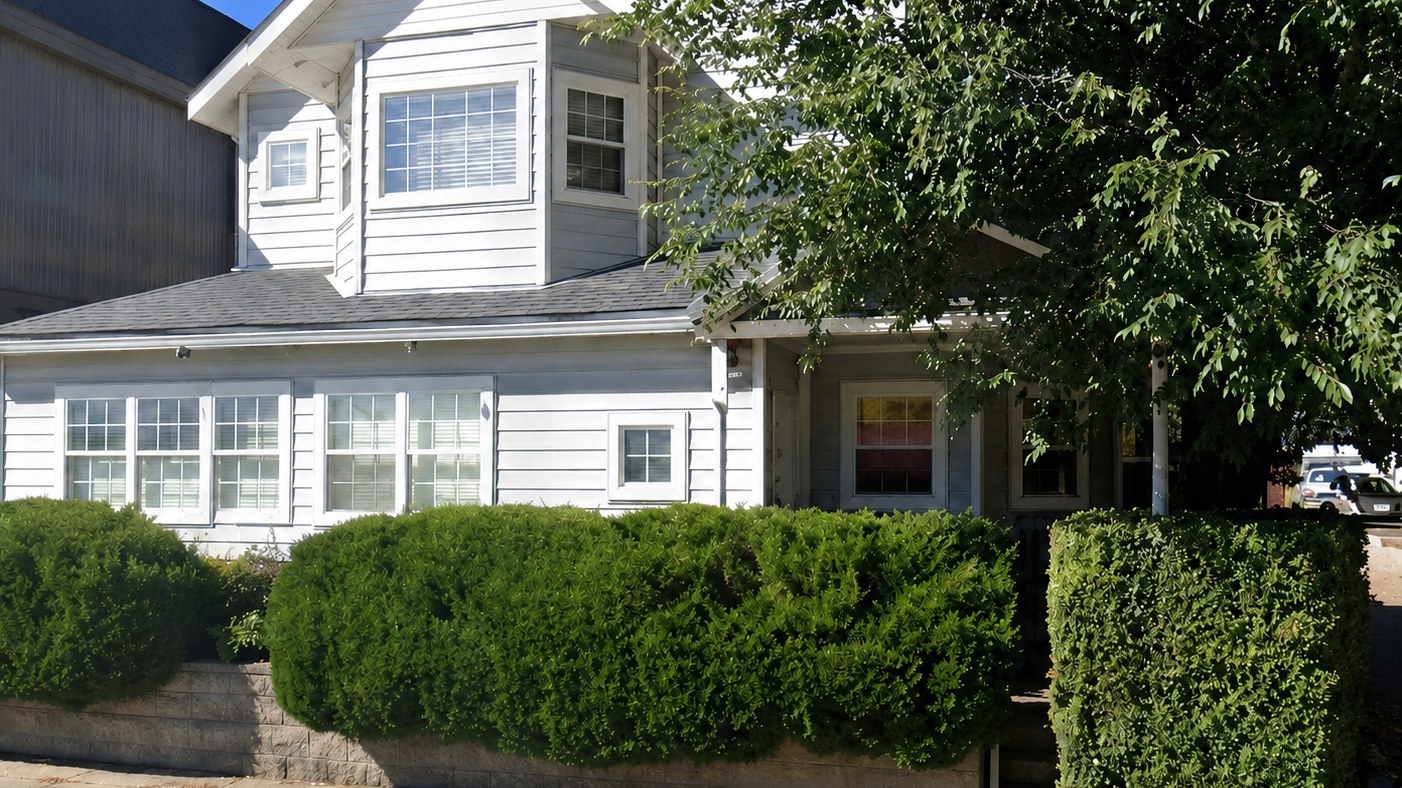 The white two-storey house on Main Ave in Durango where Jodie&rsquo;s office is, set behind a clipped hedge